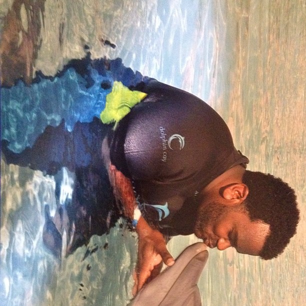 Craig Robinson kissing a dolphin.